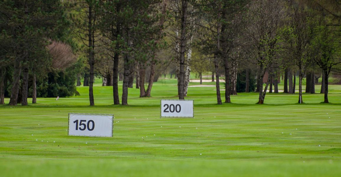 Yardage signs on a golf course practice range 