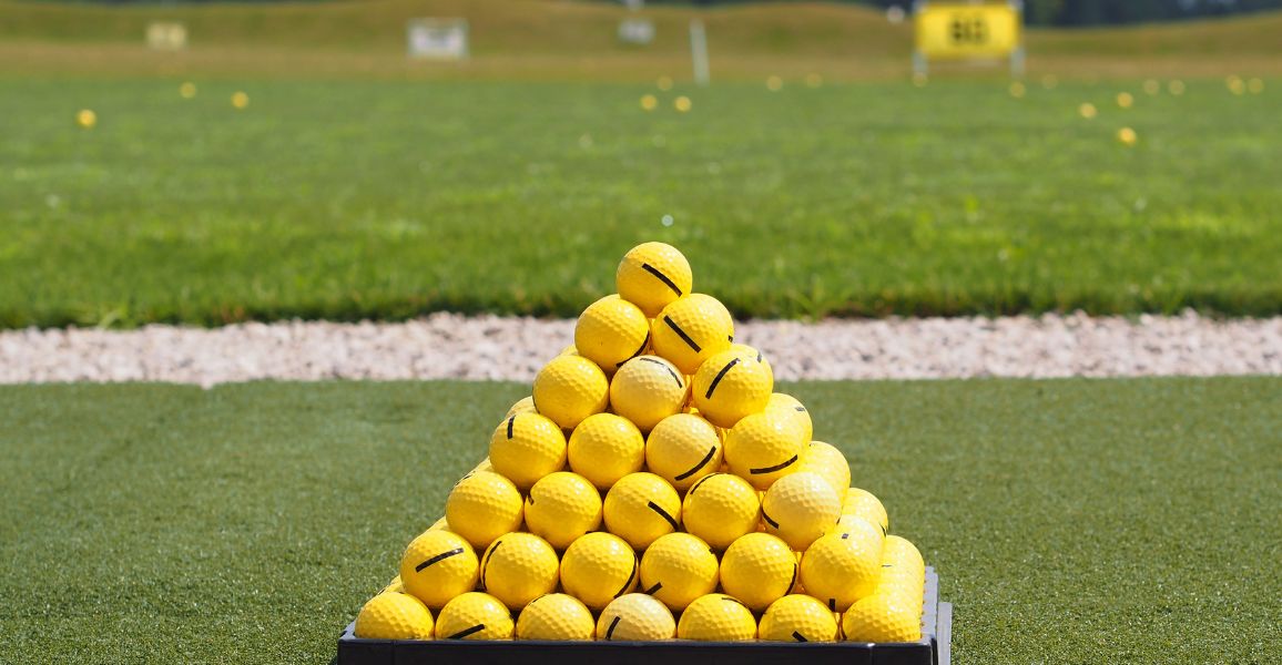 Pyramid of yellow driving range golf balls for a practice session