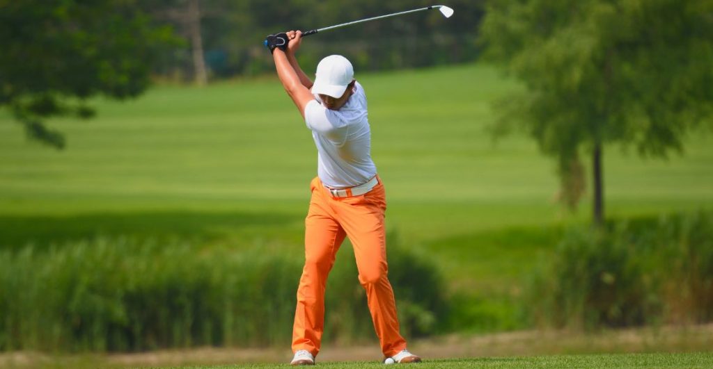 Golfer keeping his lead arm straight in orange pants