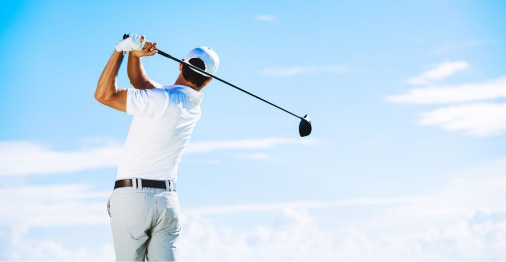 golfer swing the driver fast dressed in white
