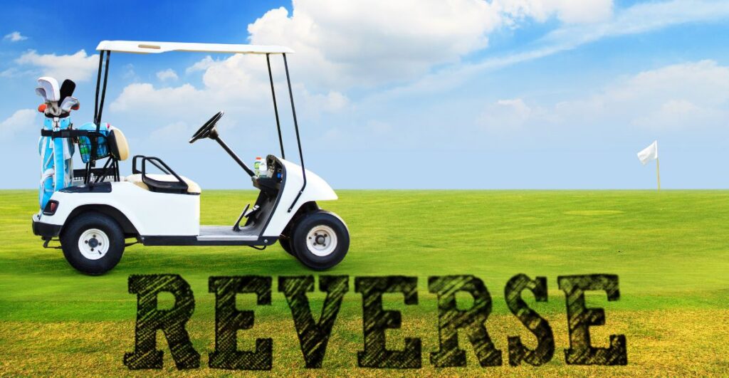 Golf cart on a fairway with the word reverse in it